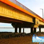 Vista inferior de un puente largo sobre el agua y la costa en marea baja