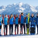 Equipo argentino de deportes de invierno posando con esquíes en la nieve rumbo a Milano-Cortina 2026