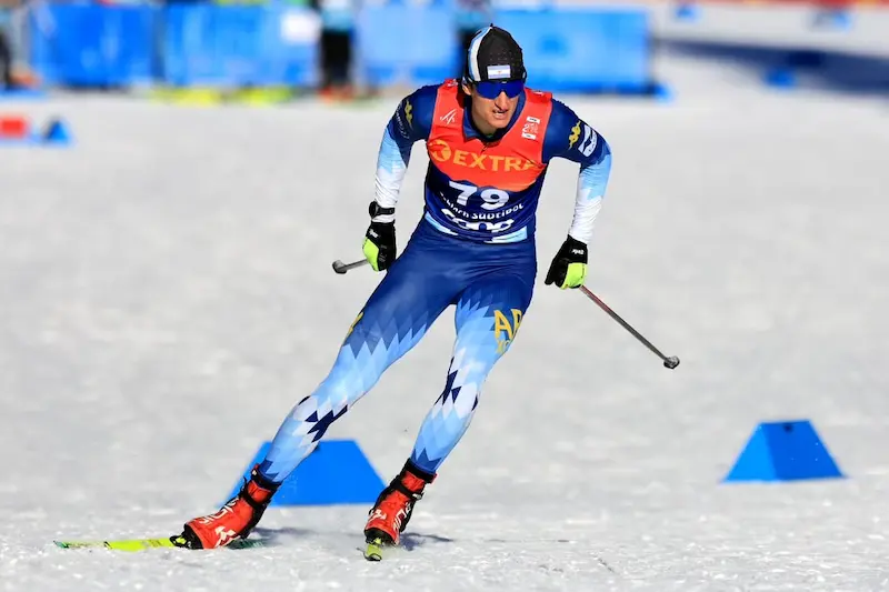 Esquiador argentino de esquí de fondo en competencia sobre nieve, con bastones y dorsal visible.
